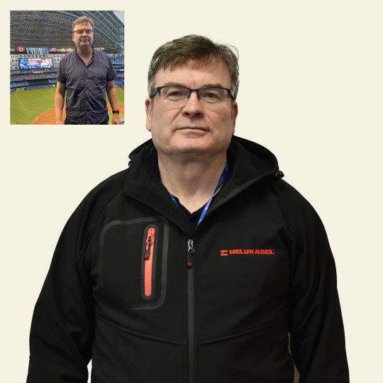 Gerry Slavin photographed in front of a football stadium in a shirt and glasses.