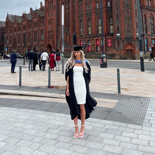 Rhiannon Mack stood outside the University of Liverpool in her graduation gown and cap.